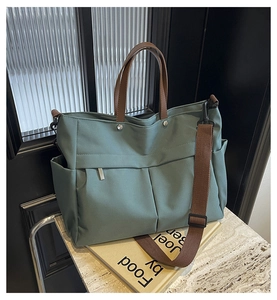 Dettaglio borsa tote in nylon verde Morandi con manici in pelle e tasche laterali