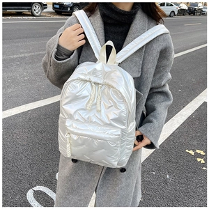 Détail du sac à dos bouffant perle blanche avec texture matelassée et tirettes tressées