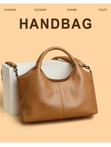 Close-up of brown pebbled leather texture and stitching on an elegant tote handbag