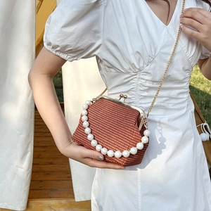 Detail of vintage woven shell bag featuring a large pearl handle and metal gold chain