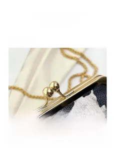 Detailed close-up of cow print shell bag showing gold metal clasp and chain