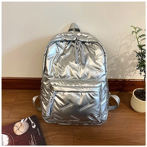 Vue détaillée du sac à dos argenté matelassé avec finition métallique et poche avant