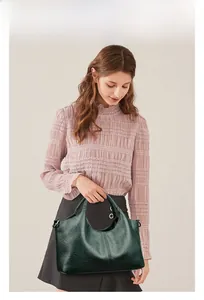 Detail of dark green hobo bag in oil wax PU leather with metal D-ring attachment
