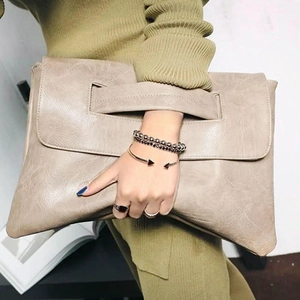 Pochette enveloppe en cuir beige avec texture et dragonne pour un style minimaliste