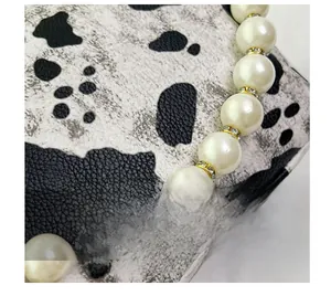 Close-up of pearl bracelet with gold rhinestone spacers on cow print texture