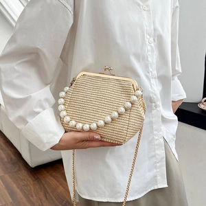 Detail of vintage woven shell bag featuring a pearl handle and gold kiss lock closure