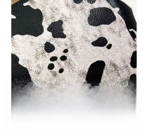 Close-up of black and white cow print leather fabric with distinct pebble grain texture