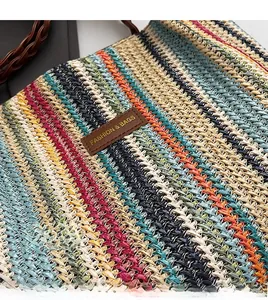 Detail of multi-colored striped woven tote with a brown leather logo and high texture