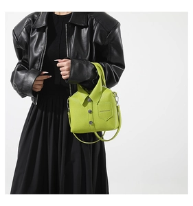 Close-up of bright green leather bag with unique shirt collar and button design