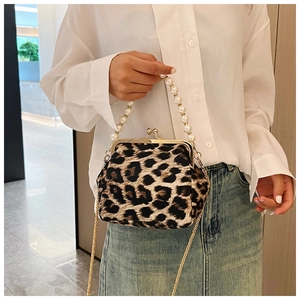 Detail of leopard print shell bag with pearl handle and golden chain shoulder strap