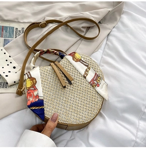 Detail of round straw bag with silk scarf handle and adjustable leather strap