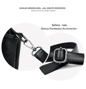 Detail view of glossy metal hardware and secure safety lock on black leather handbag