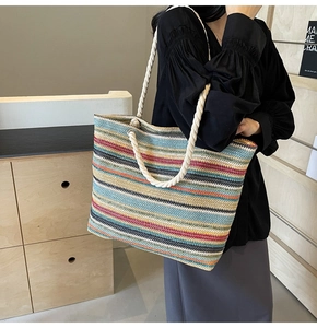 Détail du sac cabas tissé à rayures colorées avec anses en corde de coton et œillets métal