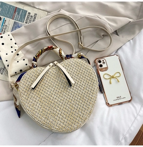 Detail of heart-shaped straw bag with silk ribbon handle and adjustable strap