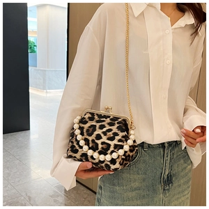 Detail of leopard print shell bag with large pearl handle and golden chain strap