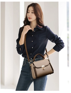 Detail of khaki leather handbag with gold twist lock and brown top handle on a model