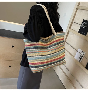 Détail du sac cabas tissé à rayures colorées avec anses en corde et œillets en métal