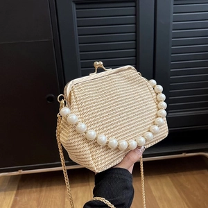 Detail of beige woven mini bag with luxury faux pearl handle and gold chain strap