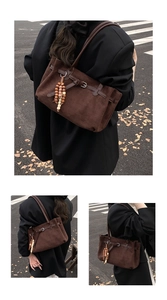 Dettaglio della borsa tote in pelle scamosciata marrone con perline in legno e fibbia
