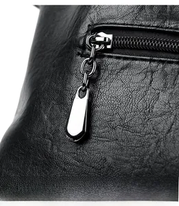 Close-up of premium black lychee leather texture and silver teardrop zipper detail