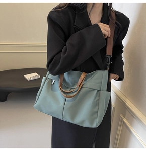 Dettaglio della borsa tote in nylon verde chiaro con manici marroni e tasca laterale