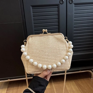 Detail of woven straw bag with pearl handle, gold metal clasp and chain strap