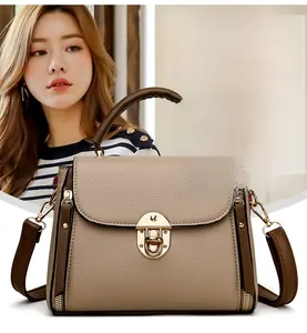 Detail of two-tone brown tote bag featuring pebbled leather texture and gold buckle