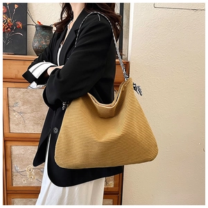 Detail of corduroy tote bag featuring a mustard yellow texture and geometric strap