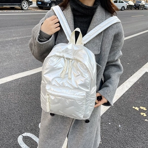Photo street style d'un sac à dos matelassé blanc métallisé avec de larges bretelles