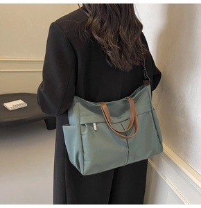 Dettaglio della borsa tote in nylon grigio-verde con doppi manici e tracolla regolabile