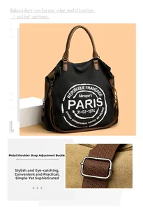 Detail of adjustable metal buckle and woven strap on black canvas tote bag