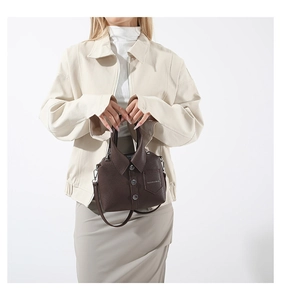 Detail of creative shirt-style crossbody bag in dark coffee lychee leather with buttons