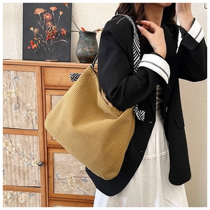 Close-up of khaki corduroy tote bag featuring striped texture and twill bow shoulder strap