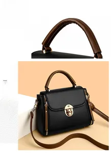 Detail of sturdy handle and crossbody bag with litchi grain texture and gold clasp