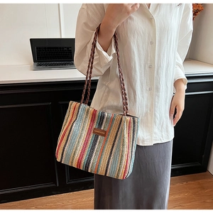 Detail of colorful striped woven tote bag featuring a brown leather fashion tag