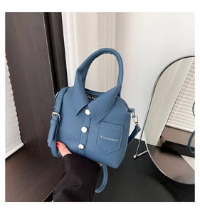 Macro detail of the shirt-shaped leather handbag showing collar and metal button accents