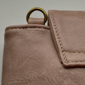 Gros plan d'un sac en similicuir grainé avec coutures et détails d'anneau en D bronze