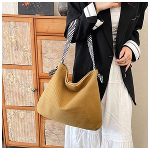 Detail of ginger corduroy tote bag featuring striped woven strap and drawstring closure