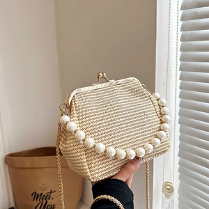 Detail of vintage woven shell bag with pearl handle and gold chain strap close-up