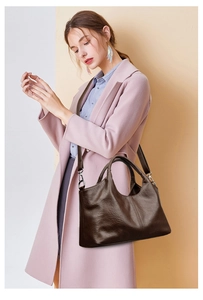 Detailed view of deep brown vintage soft leather tote bag worn over the shoulder by model
