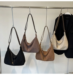 Detail view of four suede hobo bags in various colors with contrast stitching decoration