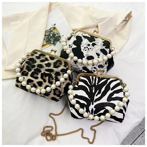 Detail of retro shell bags with leopard, cow, and zebra prints featuring pearl handles