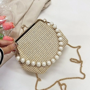 Chic woven shell bag with pearl handle and gold chain strap in a natural beige tone