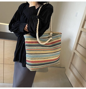 Détail d'un sac cabas tissé à rayures multicolores avec de larges poignées en corde