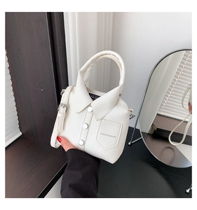 Detail of creative shirt-shaped white leather handbag with metal buttons and shoulder strap