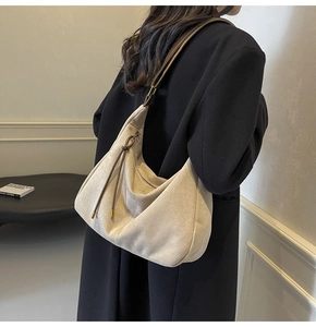 Detailed side view of off-white suede hobo bag showing its large capacity and soft texture