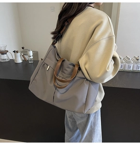 Dettaglio della grande borsa tote in nylon con manici in pelle e tracolla regolabile