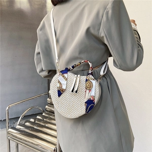 Chic heart-shaped woven straw bag with decorative silk ribbon and white shoulder strap