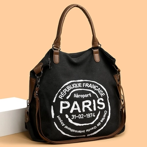 Large black canvas tote bag with Paris graphic, brown leather handles and shoulder strap