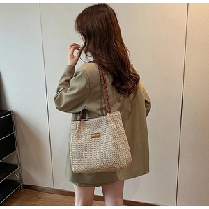 Detail of the woven texture and twisted leather strap on this large straw tote bag
